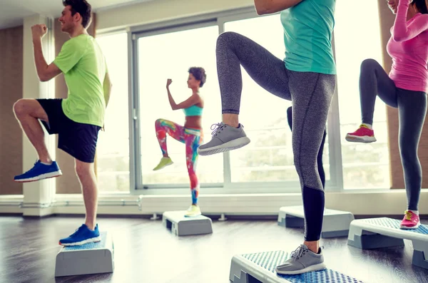 group of people raising legs on step platforms