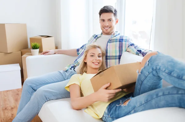 Feliz pareja con grandes cajas de cartón en el nuevo hogar —  Fotos de Stock