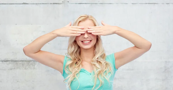 Lächelnde junge Frau oder Teenagerin, die ihre Augen bedeckt — Stockfoto