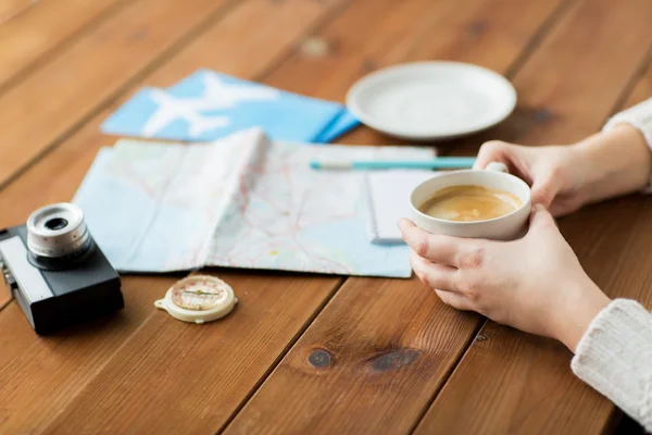 Primer plano de las manos con taza de café y cosas de viaje — Foto de Stock