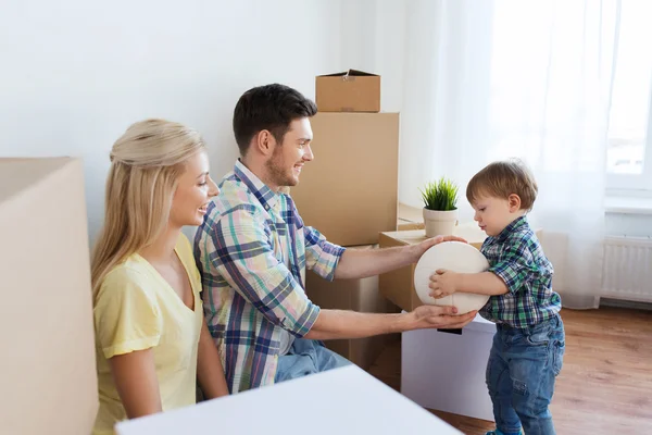 Familia feliz mudándose a un nuevo hogar y jugando pelota — Foto de Stock