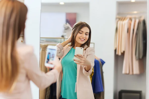 Woman taking mirror selfie by smartphone at store — Stock Photo, Image