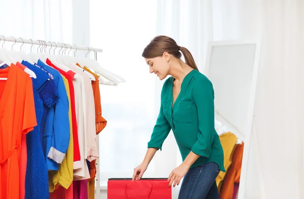 Happy woman with shopping bags and clothes at home — Stock Photo, Image