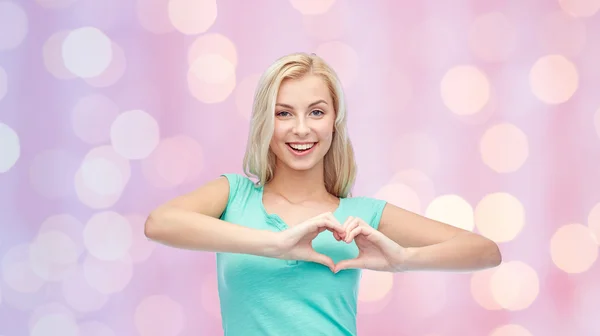 Happy woman or teen girl showing heart shape sigh — Stok fotoğraf