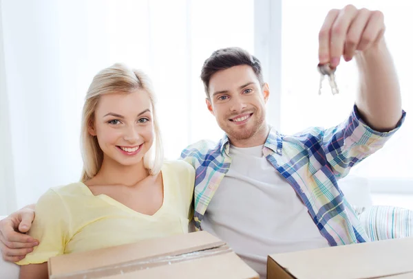 Счастливая пара с ключом и коробками, переезжающая в новый дом — стоковое фото