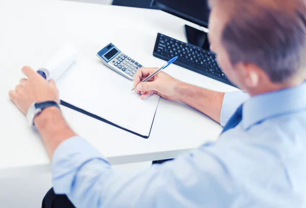 Zakenman met notebook en rekenmachine — Stockfoto