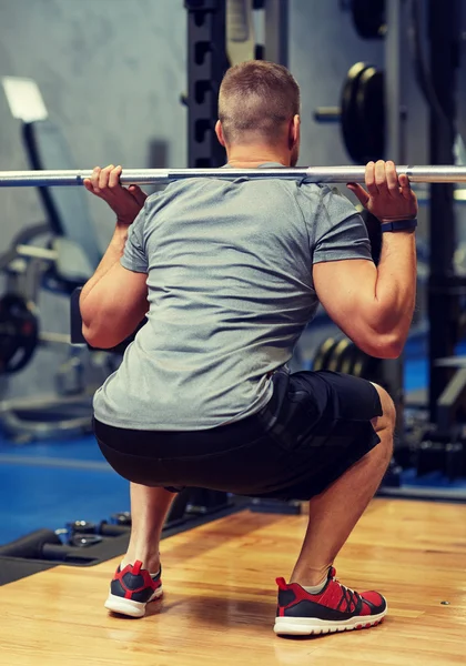 Fiatal férfi flexing izmok súlyzó tornateremben — Stock Fotó