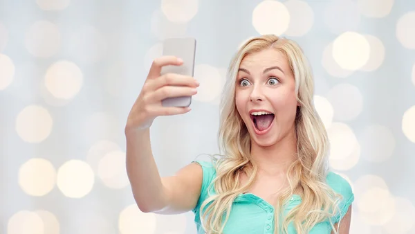 Smiling young woman taking selfie with smartphone — Stock Photo, Image