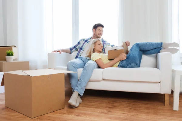 Feliz pareja con grandes cajas de cartón en el nuevo hogar — Foto de Stock