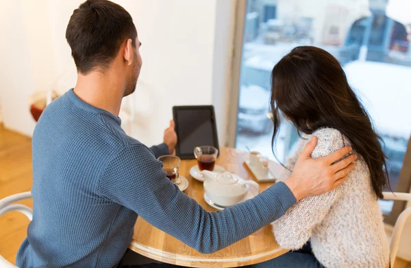 Happy couple with tablet pc drinking tea at cafe — Stock Photo, Image