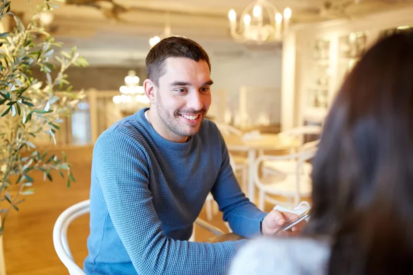 Счастливая пара разговаривает в кафе или ресторане — стоковое фото