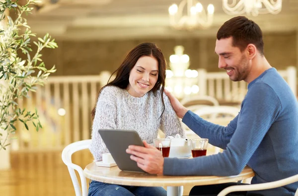 Ευτυχισμένο ζευγάρι με το tablet pc σας πίνοντας τσάι στο café — Φωτογραφία Αρχείου