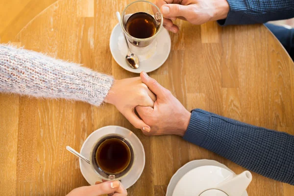 Primer plano de pareja cogida de la mano en el restaurante — Foto de Stock