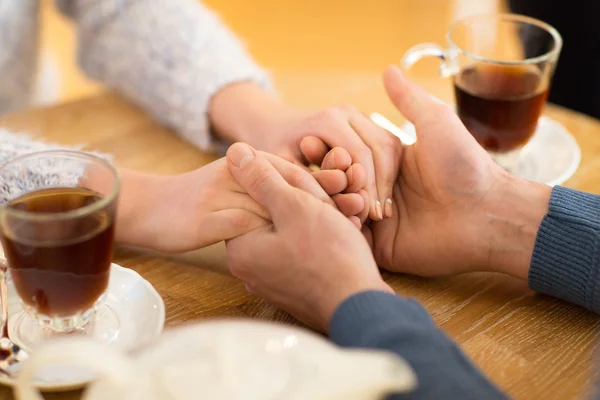Primer plano de pareja cogida de la mano en el restaurante — Foto de Stock