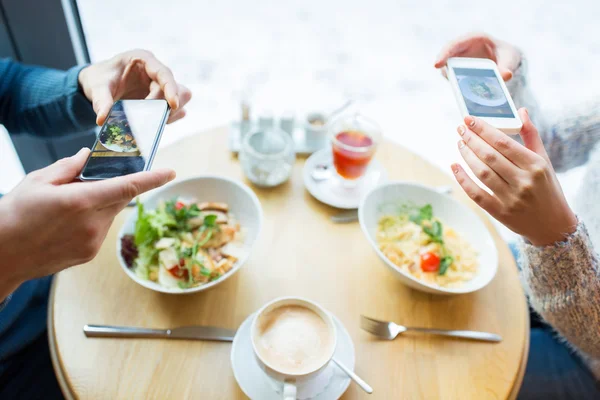 Close-up de casal imaginando comida por smartphone — Fotografia de Stock