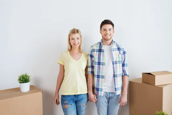 Улыбающаяся пара с большими коробками, переезжающими в новый дом — стоковое фото