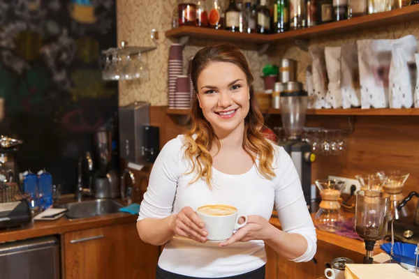 Gelukkig barista vrouw met latte bij koffie shop — Stockfoto