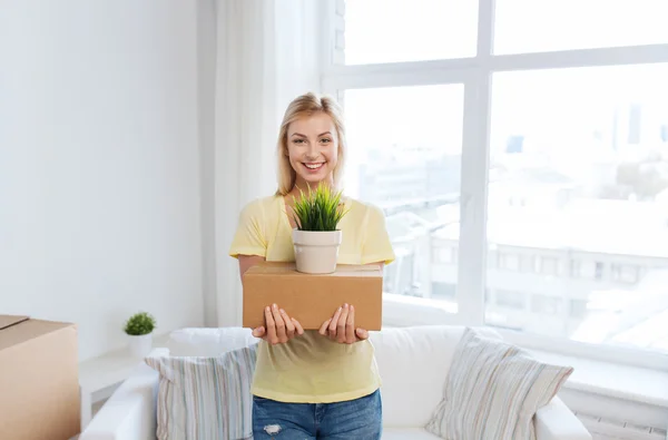 Giovane donna sorridente con scatola di cartone a casa — Foto Stock