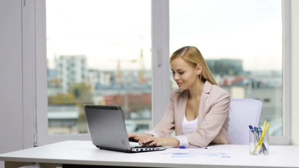 Smiling businesswoman with laptop and papers — Stock Video