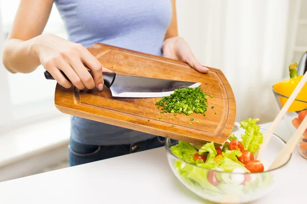 Close up of woman with chopped onion cooking salad — Stock Photo, Image