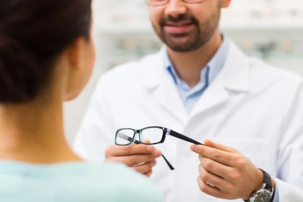 Close up of optician with glasses at optics store — Stock Photo, Image