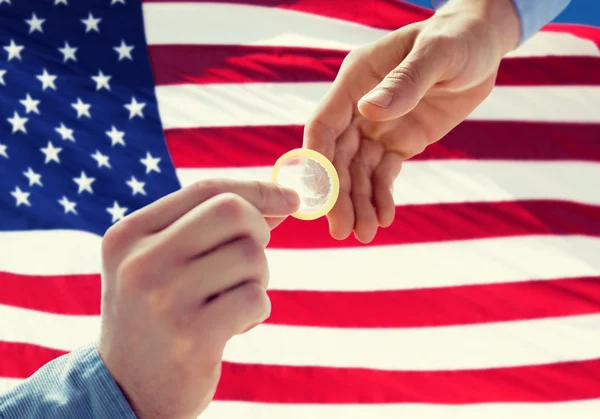 Close up of male gay couple hands giving condom — Stock Photo, Image