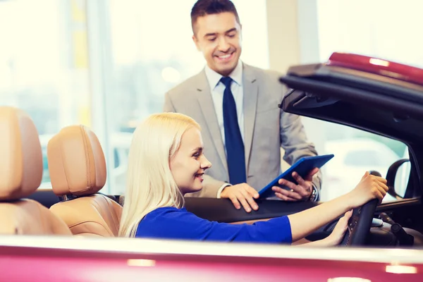 Happy woman with car dealer in auto show or salon — Stock Photo, Image
