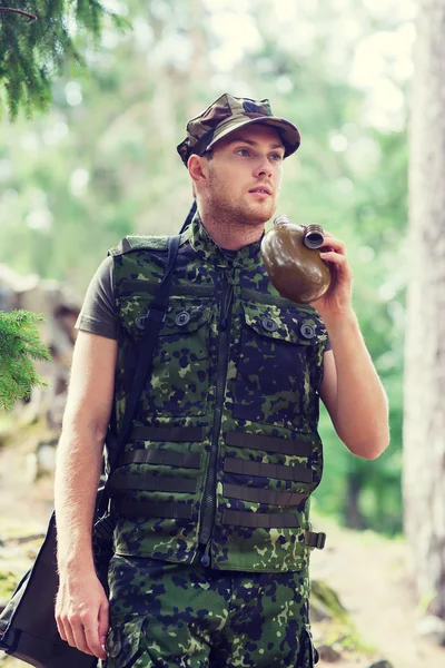 Jeune soldat avec pistolet et flasque en forêt — Photo