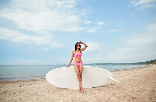 Leende ung kvinna med surfbräda på stranden — Stockfoto