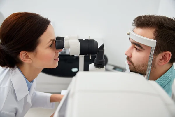Оптик с тонометром и пациентом в глазной клинике — стоковое фото