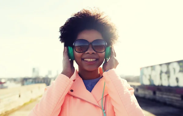 Szczęśliwa młoda kobieta w słuchawki słuchać muzyki — Zdjęcie stockowe