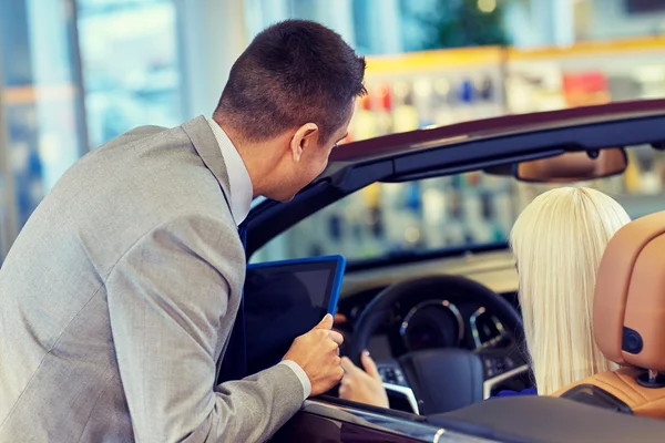 Mulher e negociante de carro com tablet pc no salão de auto — Fotografia de Stock