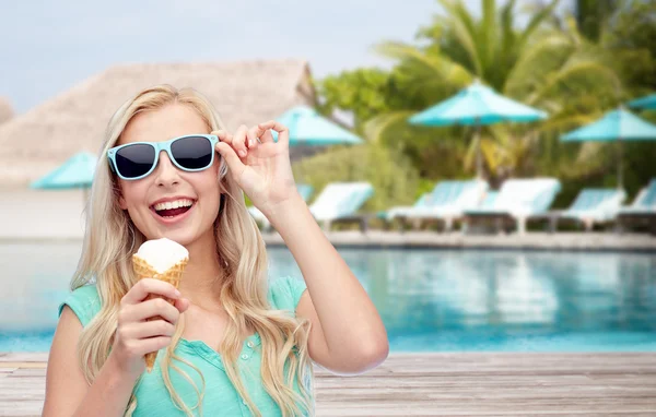 Счастливая женщина в солнечных очках с мороженым на пляже — стоковое фото