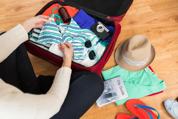 Close up of woman packing travel bag for vacation — Stock Photo, Image