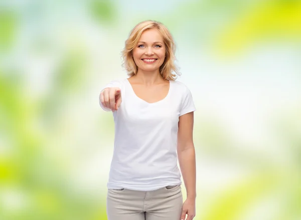 Mulher sorridente em t-shirt branca apontando para você — Fotografia de Stock