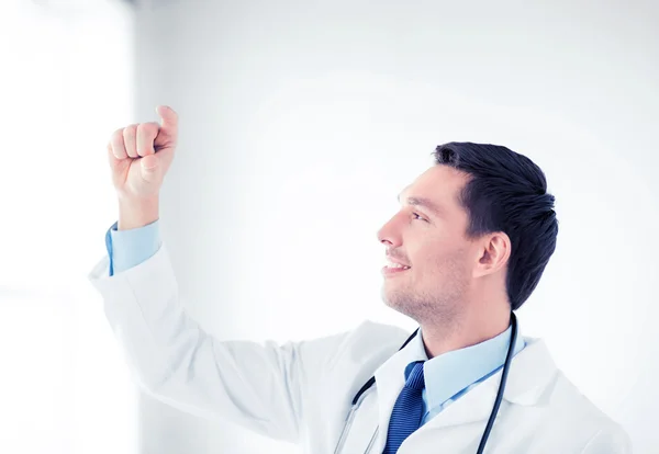 Young doctor holding something imaginary — Stock Photo, Image