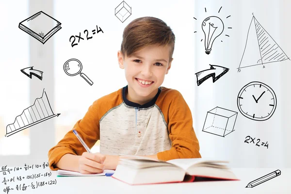 Estudiante sonriente escribiendo a cuaderno en casa —  Fotos de Stock