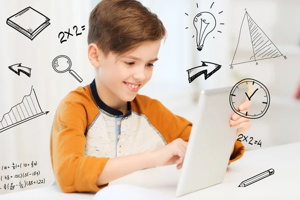 Улыбающийся мальчик с планшетным компьютером дома — стоковое фото