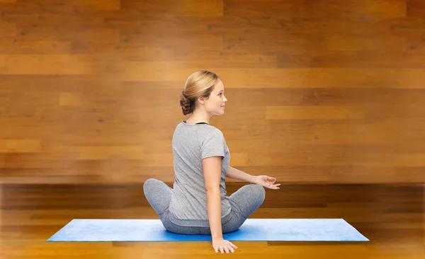 Femme faisant du yoga en pose tordue sur le tapis — Photo