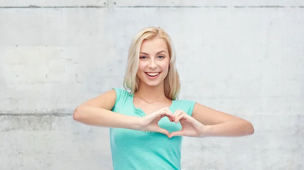 Happy woman or teen girl showing heart shape sigh — Stockfoto