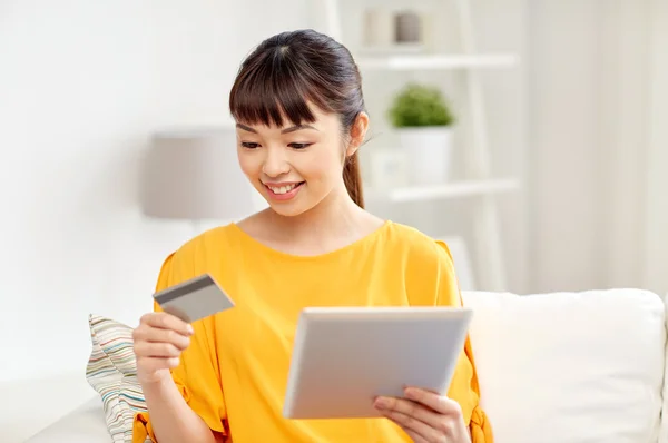 Счастливая азиатская женщина с планшетным ПК и кредитной карты — стоковое фото