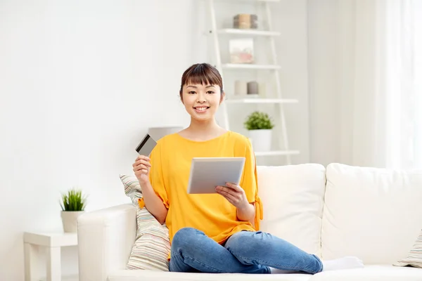 Glücklich asiatische Frau mit Tablet-PC und Kreditkarte — Stockfoto