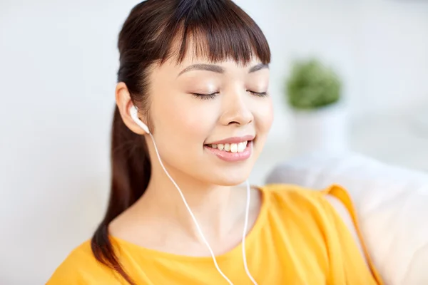 Счастливая азиатка с наушниками, слушающая музыку — стоковое фото