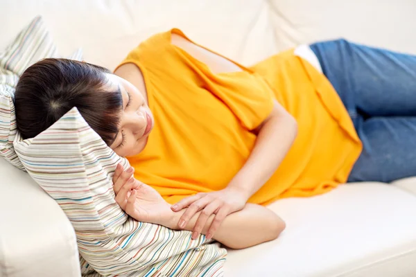 Happy asian teenage girl sleeping on sofa at home — Stock Photo, Image