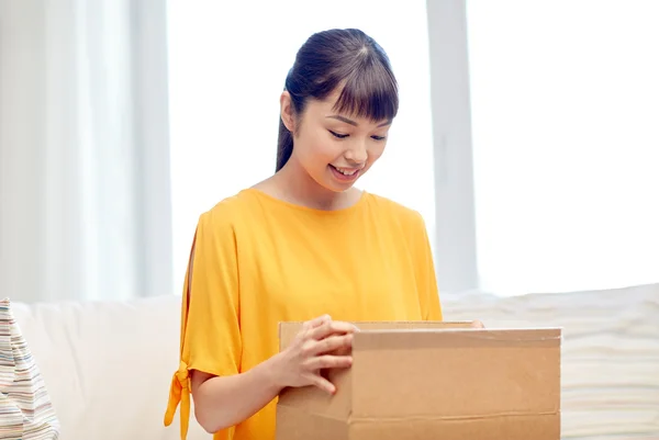 Happy asian young woman with parcel box at home — Stock Photo, Image