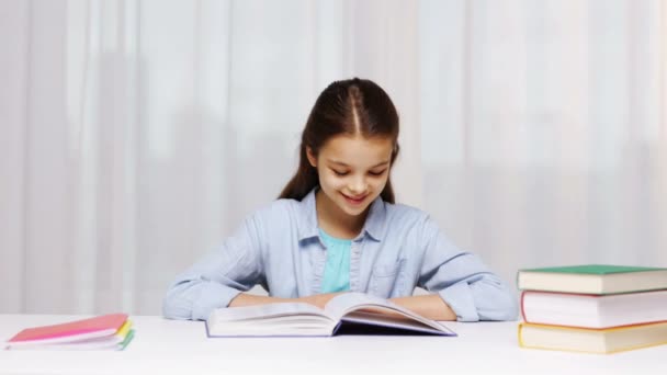 Menina da escola feliz ler livro ou livro didático em casa — Vídeo de Stock