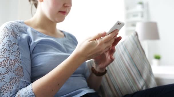 Jovem mulher feliz com smartphone em casa — Vídeo de Stock