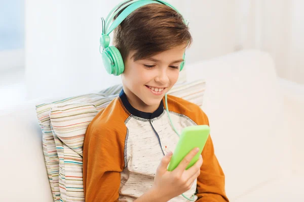 Happy boy with smartphone and headphones at home — Stock Photo, Image