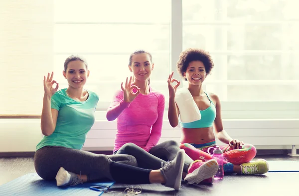 Happy women with water showing ok sign in gym — Stock Photo, Image