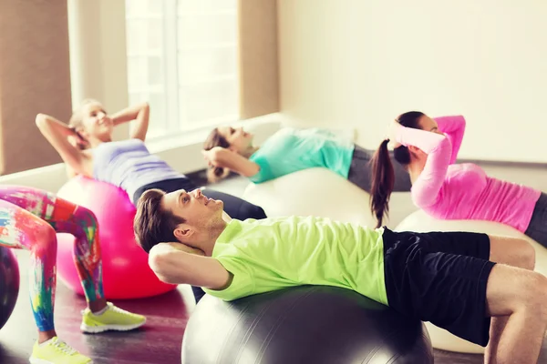 Happy people flexing abdominal muscles on fitball — Stock Photo, Image